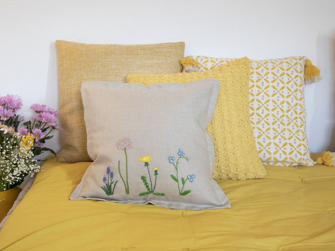 Blumenstickereien auf Kissen auf einem Bett